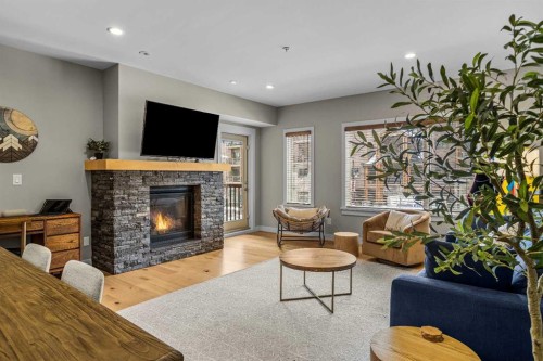 200-707 Spring Creek Drive, Canmore, AB - Indoor Photo Showing Living Room With Fireplace