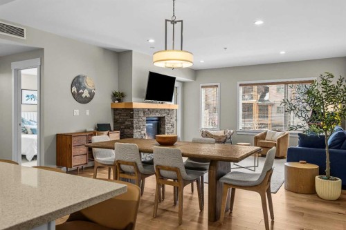200-707 Spring Creek Drive, Canmore, AB - Indoor Photo Showing Dining Room With Fireplace