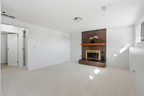 107 Nottingham Road, Calgary, AB - Indoor Photo Showing Living Room With Fireplace