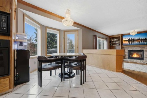 729 Woodbriar Place Sw, Calgary, AB - Indoor Photo Showing Dining Room With Fireplace