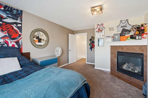 144 Canals Circle Sw, Airdrie, AB - Indoor Photo Showing Bedroom With Fireplace