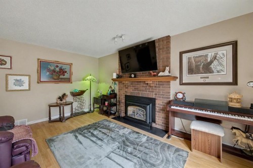 983 Woodbine Boulevard Sw, Calgary, AB - Indoor Photo Showing Living Room With Fireplace