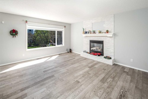 32 Cougarstone Square Sw, Calgary, AB - Indoor Photo Showing Living Room With Fireplace