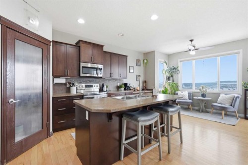 99 Sunset View, Cochrane, AB - Indoor Photo Showing Kitchen With Stainless Steel Kitchen With Double Sink With Upgraded Kitchen