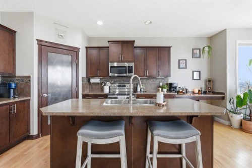 99 Sunset View, Cochrane, AB - Indoor Photo Showing Kitchen With Stainless Steel Kitchen With Double Sink With Upgraded Kitchen