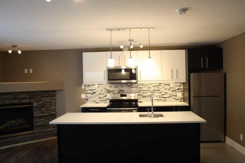 37 Chaparral Ridge Link Se, Calgary, AB - Indoor Photo Showing Kitchen With Fireplace