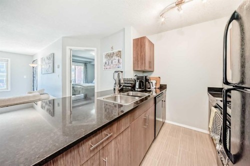 1305-403 Mackenzie Way Sw, Airdrie, AB - Indoor Photo Showing Kitchen With Double Sink