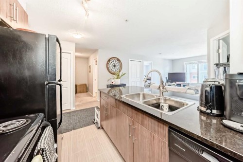 1305-403 Mackenzie Way Sw, Airdrie, AB - Indoor Photo Showing Kitchen With Double Sink
