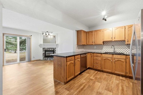 4B Millview Way Sw, Calgary, AB - Indoor Photo Showing Kitchen With Fireplace