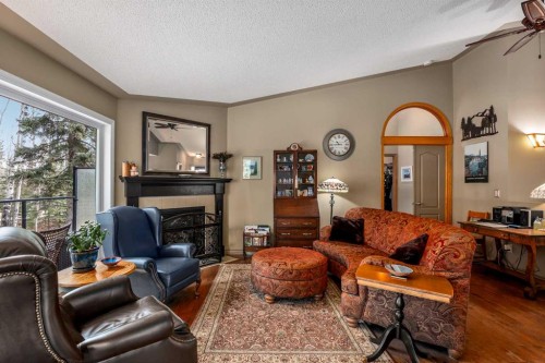 94 Sunset Way, Priddis Greens, AB - Indoor Photo Showing Living Room With Fireplace