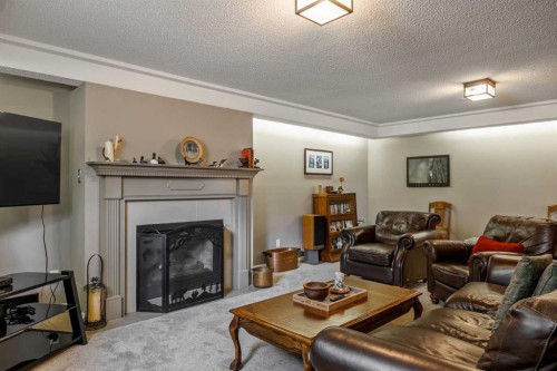 94 Sunset Way, Priddis Greens, AB - Indoor Photo Showing Living Room With Fireplace