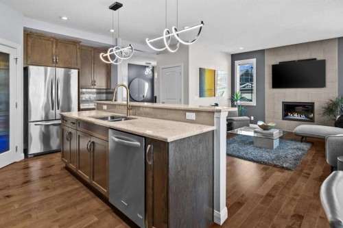 100 Kinniburgh Gardens, Chestermere, AB - Indoor Photo Showing Kitchen With Fireplace With Stainless Steel Kitchen With Double Sink With Upgraded Kitchen
