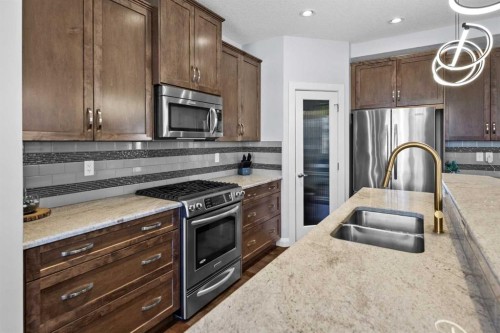 100 Kinniburgh Gardens, Chestermere, AB - Indoor Photo Showing Kitchen With Stainless Steel Kitchen With Double Sink With Upgraded Kitchen