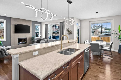 100 Kinniburgh Gardens, Chestermere, AB - Indoor Photo Showing Kitchen With Fireplace With Double Sink