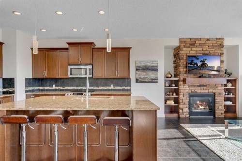 287 Sunset View, Cochrane, AB - Indoor Photo Showing Kitchen With Fireplace With Double Sink