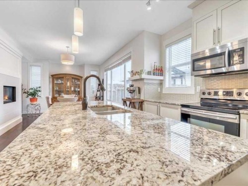 201 Rainbow Falls Glen, Chestermere, AB - Indoor Photo Showing Kitchen With Fireplace With Stainless Steel Kitchen With Double Sink With Upgraded Kitchen