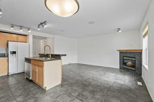 2317 Eversyde Avenue Sw, Calgary, AB - Indoor Photo Showing Kitchen With Fireplace With Double Sink
