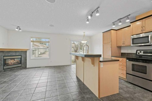 2317 Eversyde Avenue Sw, Calgary, AB - Indoor Photo Showing Kitchen With Fireplace