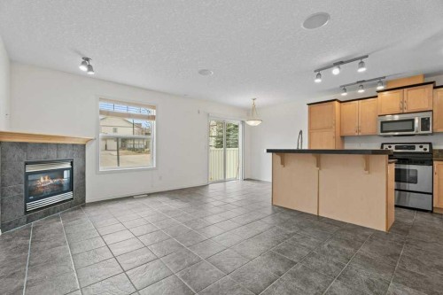 2317 Eversyde Avenue Sw, Calgary, AB - Indoor Photo Showing Kitchen With Fireplace