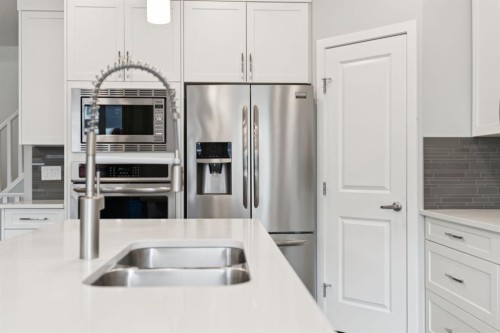 107 Sundown View, Cochrane, AB - Indoor Photo Showing Kitchen With Double Sink With Upgraded Kitchen