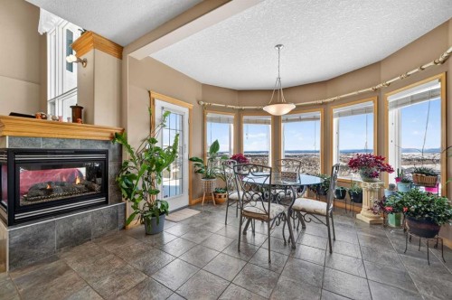 359 Rocky Ridge Drive Nw, Calgary, AB - Indoor Photo Showing Dining Room With Fireplace
