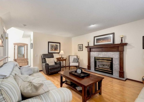 83 Gleneagles Close, Cochrane, AB - Indoor Photo Showing Living Room With Fireplace