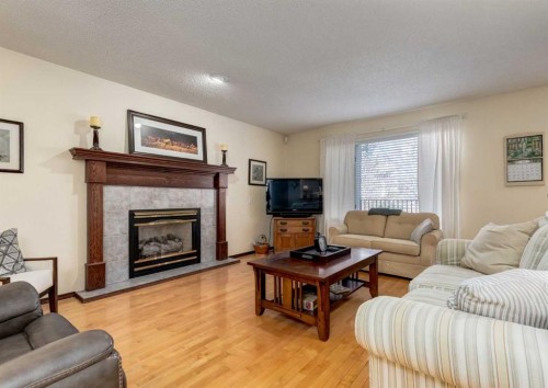 83 Gleneagles Close, Cochrane, AB - Indoor Photo Showing Living Room With Fireplace