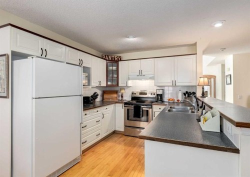 83 Gleneagles Close, Cochrane, AB - Indoor Photo Showing Kitchen With Double Sink