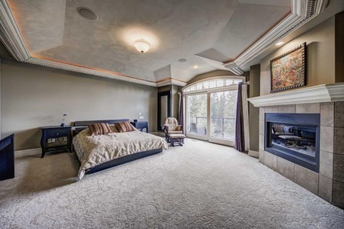 2626 Evercreek Bluffs Way Sw, Calgary, AB - Indoor Photo Showing Bedroom With Fireplace