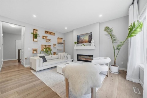 902 Bluerock Way Sw, Calgary, AB - Indoor Photo Showing Living Room With Fireplace