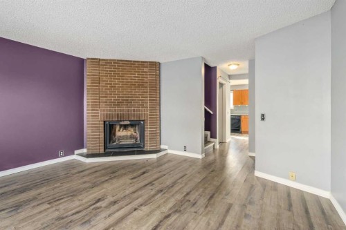19 Bernard Drive Nw, Calgary, AB - Indoor Photo Showing Living Room With Fireplace
