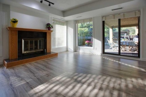 100-808 4 Avenue Nw, Calgary, AB - Indoor Photo Showing Living Room With Fireplace