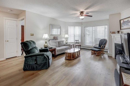 101-6800 Hunterview Drive Nw, Calgary, AB - Indoor Photo Showing Living Room With Fireplace