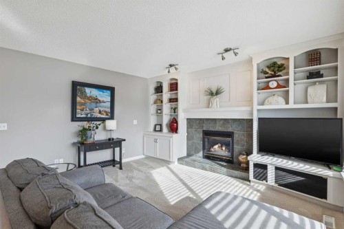 420 Rocky Ridge Bay Nw, Calgary, AB - Indoor Photo Showing Living Room With Fireplace