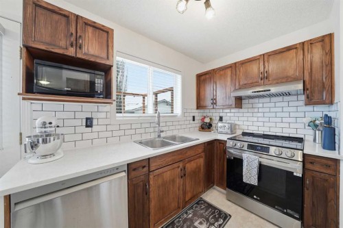 68 Bridleridge Gardens Sw, Calgary, AB - Indoor Photo Showing Kitchen With Double Sink