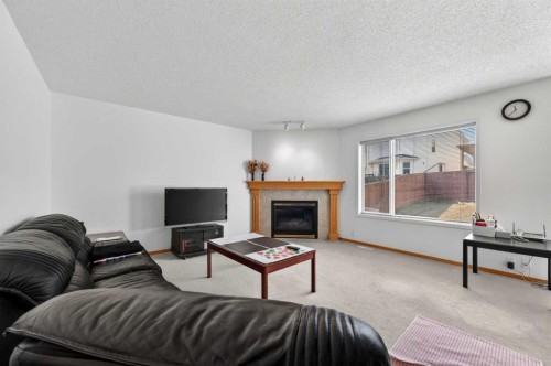 718 Coral Springs Boulevard Ne, Calgary, AB - Indoor Photo Showing Living Room With Fireplace