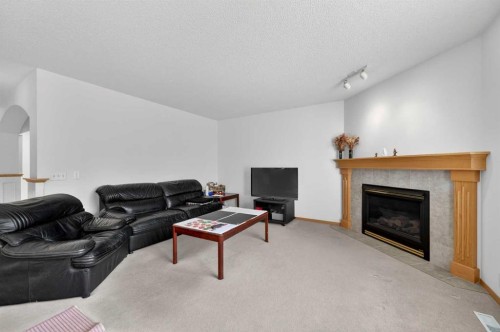 718 Coral Springs Boulevard Ne, Calgary, AB - Indoor Photo Showing Living Room With Fireplace