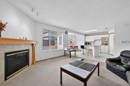 718 Coral Springs Boulevard Ne, Calgary, AB - Indoor Photo Showing Living Room With Fireplace