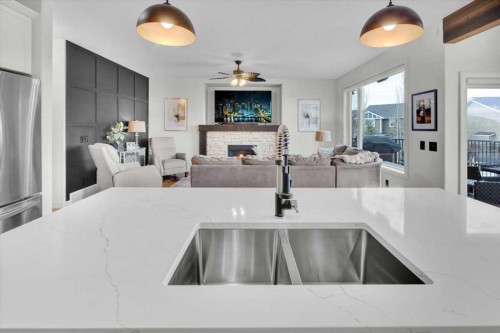 142 Fireside Bend, Cochrane, AB - Indoor Photo Showing Kitchen With Fireplace With Double Sink