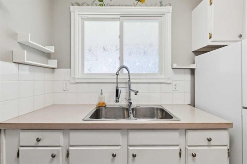 1002-2520 Palliser Drive Sw, Calgary, AB - Indoor Photo Showing Kitchen With Double Sink