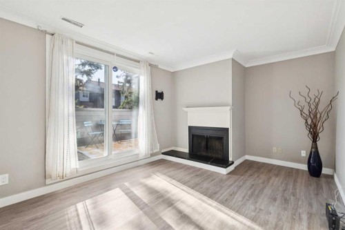 1002-2520 Palliser Drive Sw, Calgary, AB - Indoor Photo Showing Living Room With Fireplace