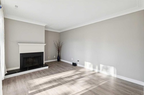 1002-2520 Palliser Drive Sw, Calgary, AB - Indoor Photo Showing Living Room With Fireplace
