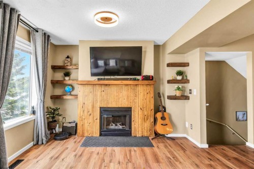 3-200 Hidden Hills Terrace Nw, Calgary, AB - Indoor Photo Showing Living Room With Fireplace