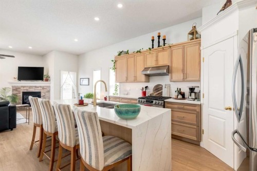 402 Rocky Ridge Cove Nw, Calgary, AB - Indoor Photo Showing Kitchen With Fireplace