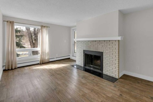 6-3402 Parkdale Boulevard Nw, Calgary, AB - Indoor Photo Showing Living Room With Fireplace