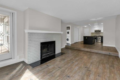 6-3402 Parkdale Boulevard Nw, Calgary, AB - Indoor Photo Showing Living Room With Fireplace