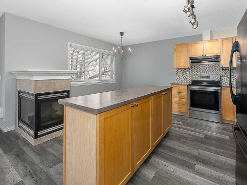 172 Simcoe Place Sw, Calgary, AB - Indoor Photo Showing Kitchen With Fireplace With Double Sink