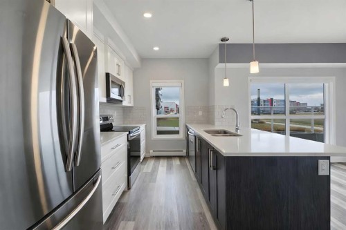 109-4150 Seton Drive Se, Calgary, AB - Indoor Photo Showing Kitchen With Stainless Steel Kitchen With Double Sink With Upgraded Kitchen