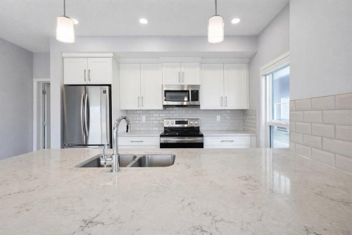 109-4150 Seton Drive Se, Calgary, AB - Indoor Photo Showing Kitchen With Stainless Steel Kitchen With Double Sink With Upgraded Kitchen