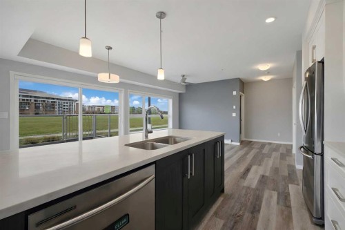 109-4150 Seton Drive Se, Calgary, AB - Indoor Photo Showing Kitchen With Stainless Steel Kitchen With Double Sink With Upgraded Kitchen
